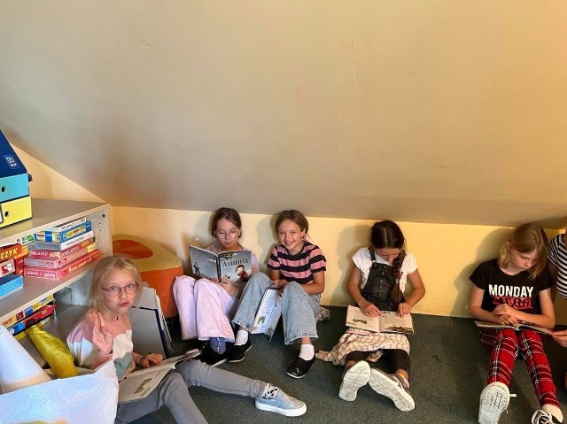 Dzieci siedzące na podłodze czytające książkę