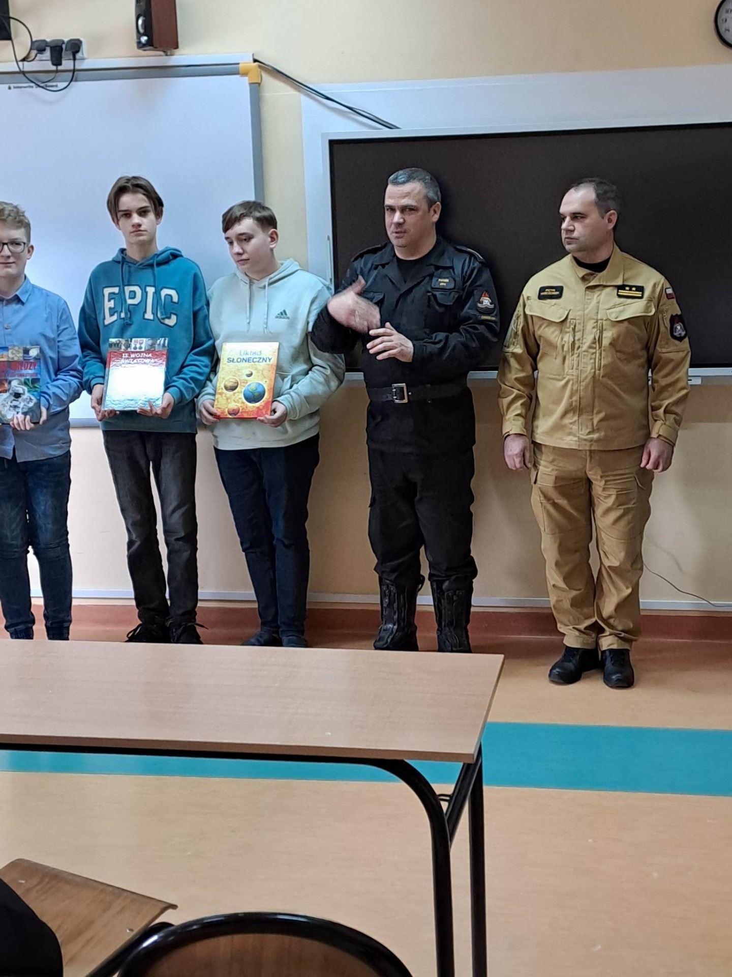 Uczniowie nagrodzeni w konkursie pożarniczym: Mikołaj, Kacper i Piotr ze strażakami 