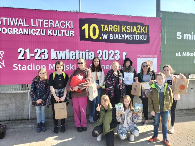 10 uczniów stoi pod różowym banerem Festiwal Literacki Pogranicza Kultury 21-23 kwietnia 2023 r.