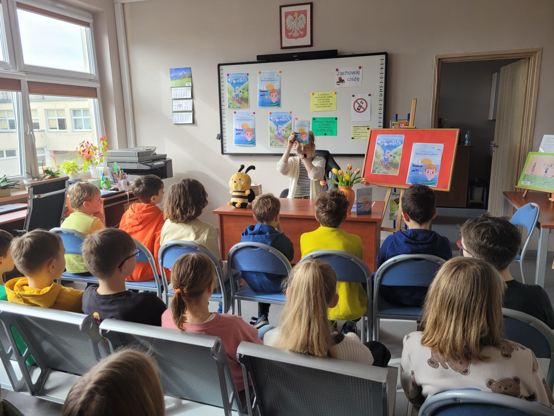 Na zdjęciu widzimy panią Kamilę Bondarowicz, autorkę książek dla dzieci, która pokazuje uczniom ilustrację do opowiadania o Ignasiu