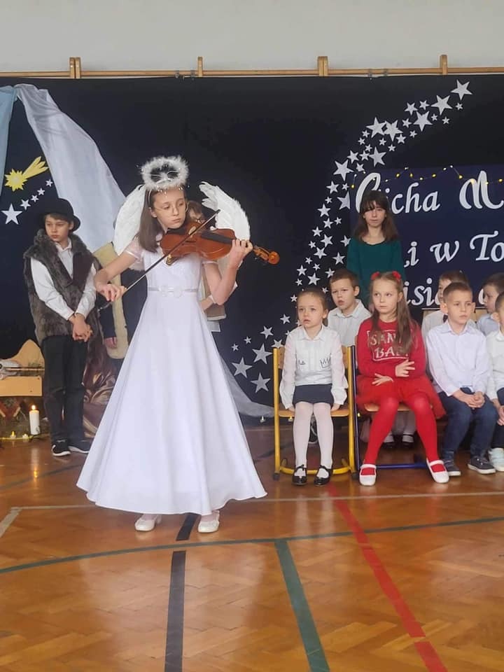 Uczennica klasy 5 gra na skrzypcach podczas występu na Jasełkach.