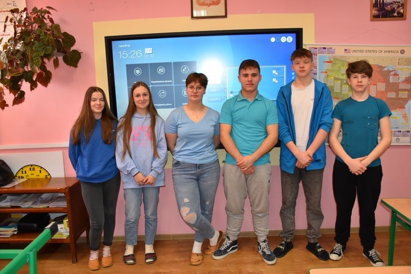 Grupa uczniów w niebieskich strojach na znak solidarności z osobami ze spektrum autyzmu