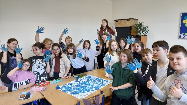Uczniowie z niebieskimi dłońmi
