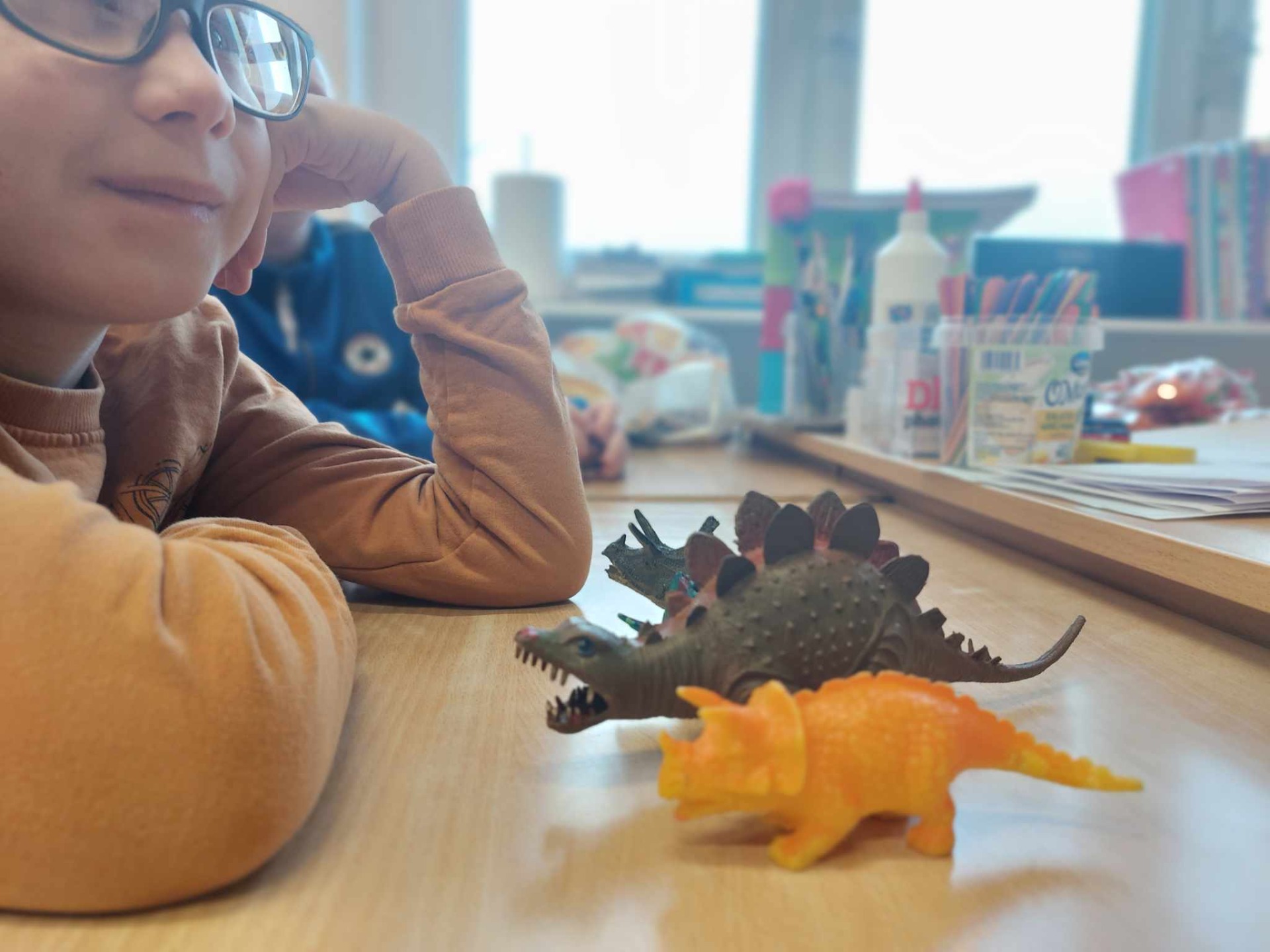 Uczeń z figurkami dinozaurów