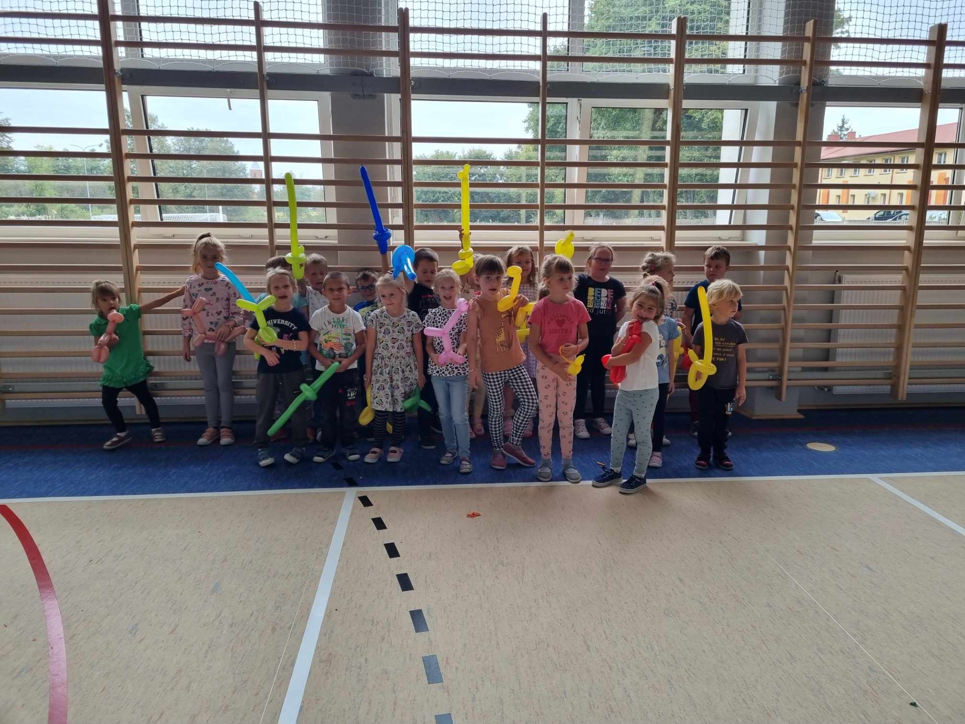 Grupa przedszkolaków z balonikami w ręku