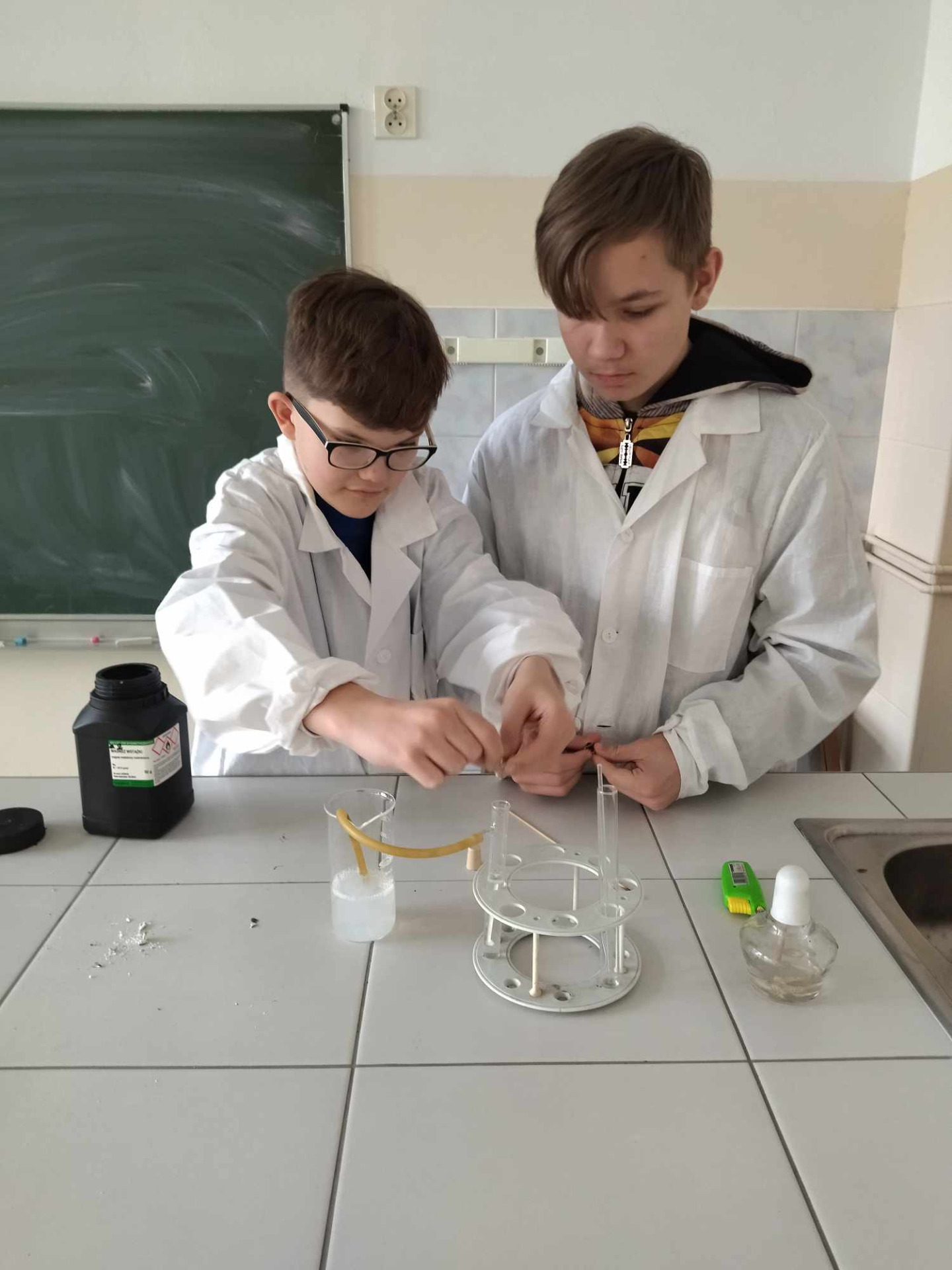 Dwaj uczniowie klasy 7a wykonują doświadczenie chemiczne.