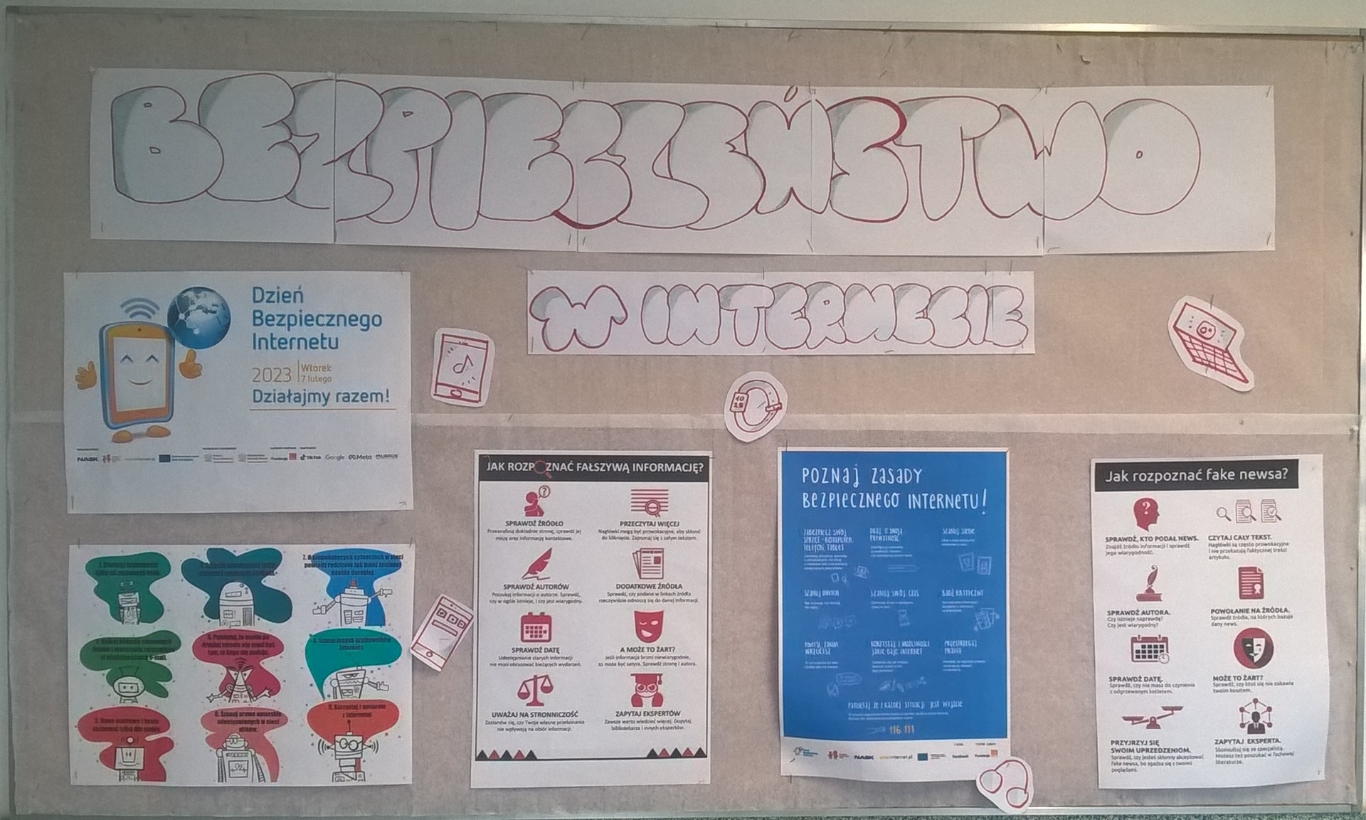 Gazetka na korytarzu szkolnym pt. Bezpieczeństwo w internecie, na której znajdują się plakaty i infografiki informujące o bezpiecznym posługiwaniu się treściami w wirtualnym świecie
