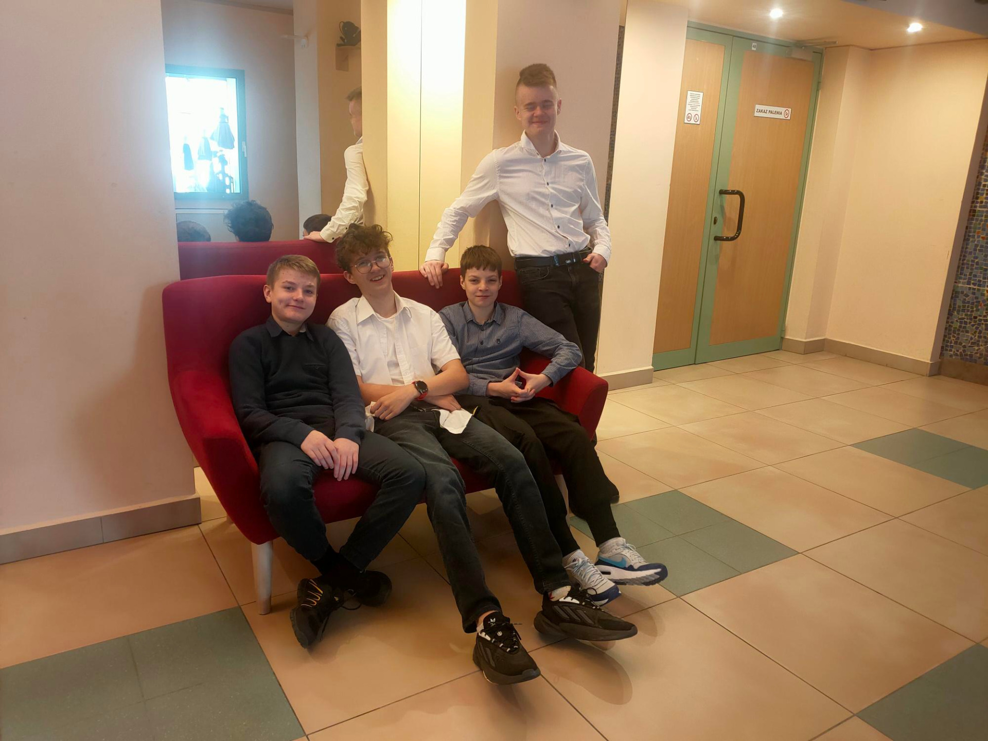 Czterech chłopców siedzi w holu teatru