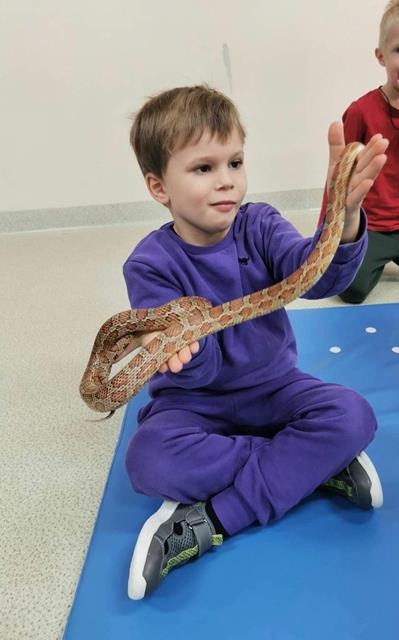 chłopiec z wężem na rękach