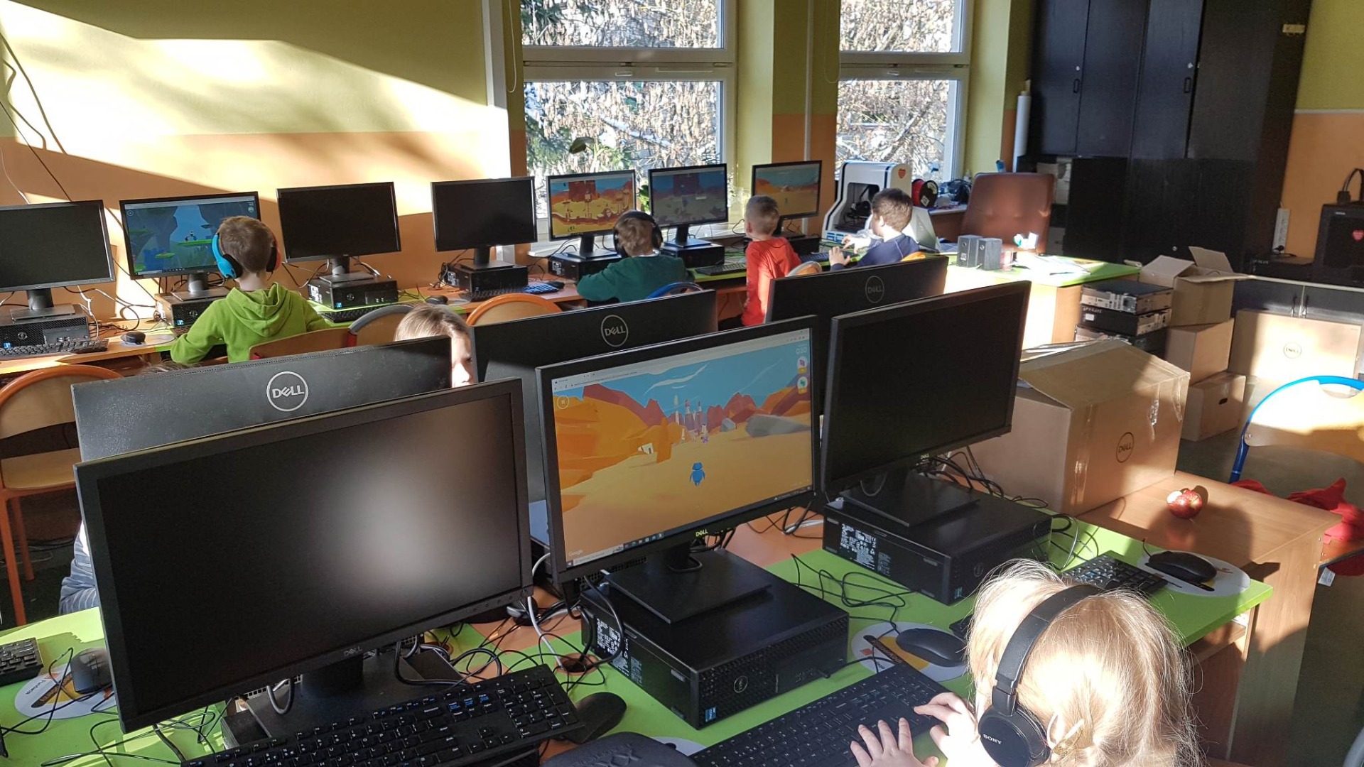 Uczniowie kl. 1b siedzą w sali informatycznej przy stanowiskach komputerowych i bawią się w  Interlandii.